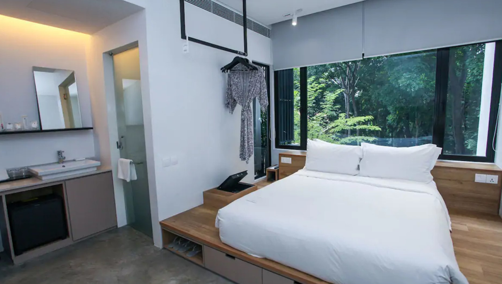 bedroom overlooking trees at one of the inns with the best hotel rates in Singapore